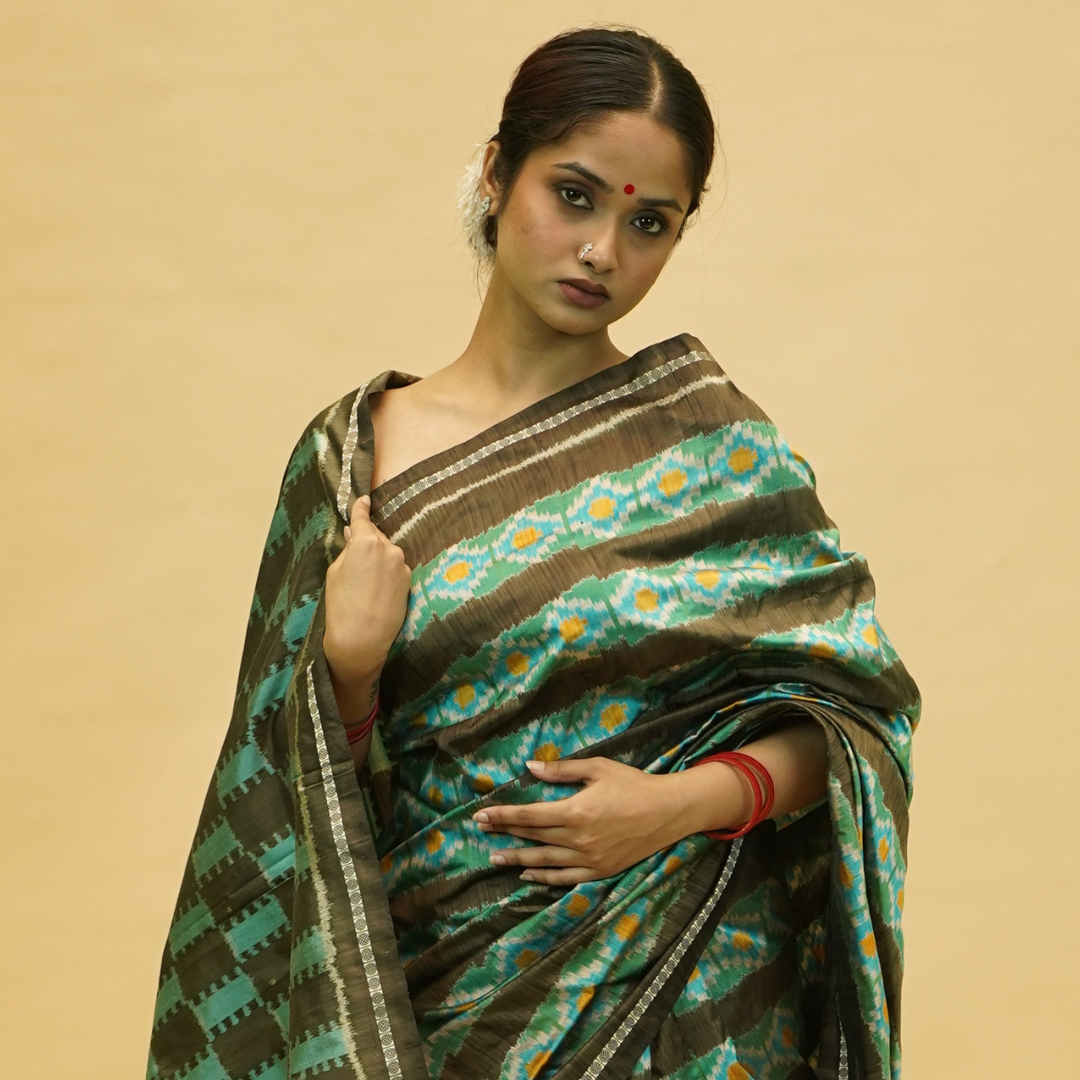 Woman wearing a traditional saree with a floral pattern on a beige background